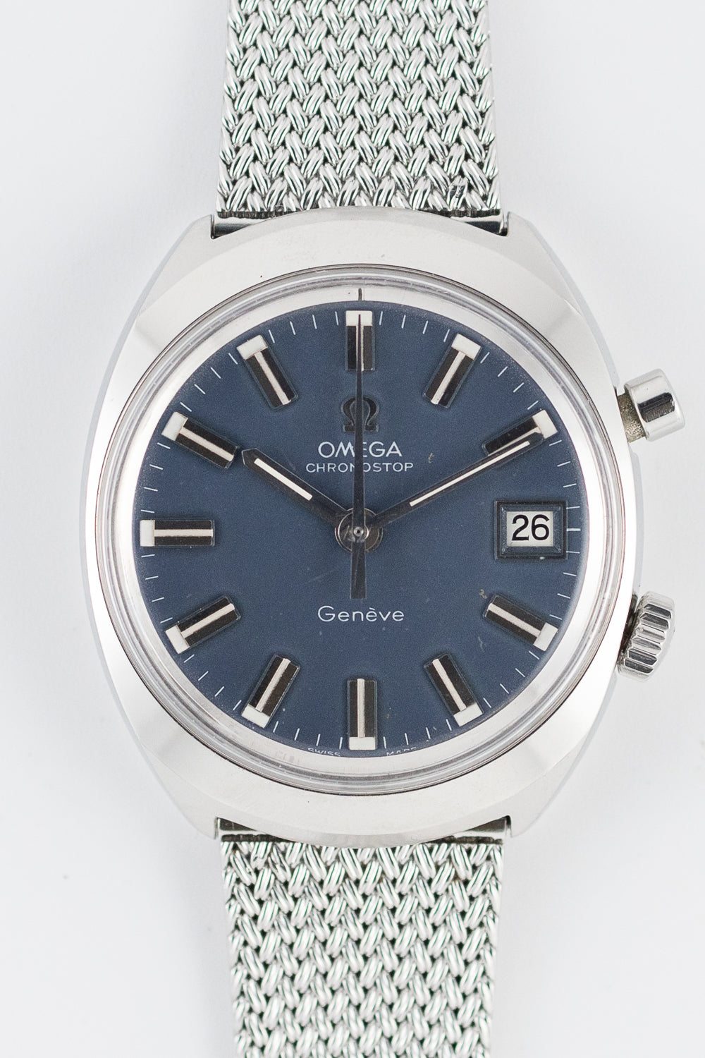Japanese-market Chronostop Date on an Omega mesh bracelet. Flat matte dark-blue dial with polished applied block markers with white painted inserts, applied Omega logo, framed date window at three and a polished (not orange) chronograph hand; no luminous plots. These are the traits of the dressy blue Japan dial. · Photo: Time Anagram · © Time Anagram, used with permission · Source: https://timeanagram.com/products/23094