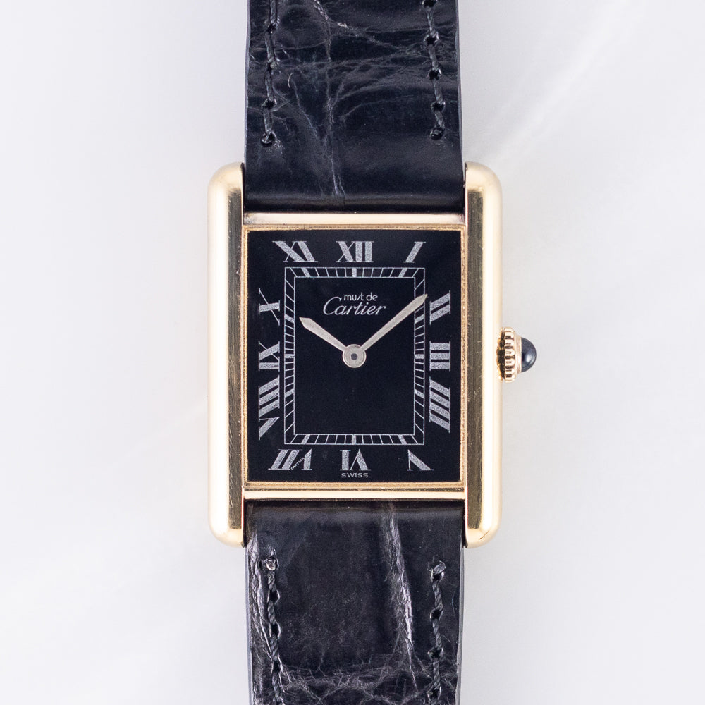Large vermeil Must de Cartier Tank with a glossy black lacquer dial printed with silver-white Roman numerals and railway track and matching silver hands, the black Roman LM variant. · Photo: Time Anagram · © Time Anagram, used with permission · Source: https://timeanagram.com/products/31255